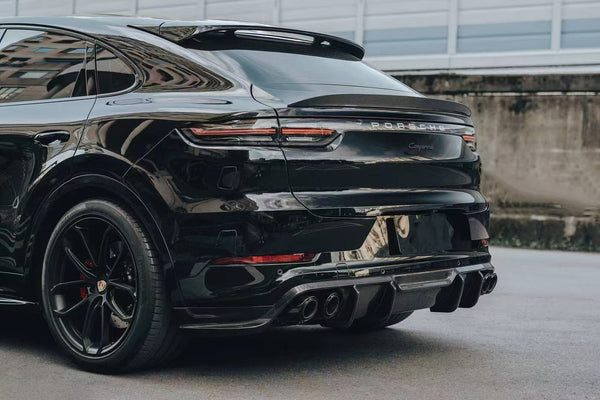 A refined rear profile of the Porsche Cayenne, upgraded with a performance rear diffuser and a sculpted spoiler. Clean lines, enhanced aerodynamics, and a purposeful stance that elevates the SUV’s modern design.