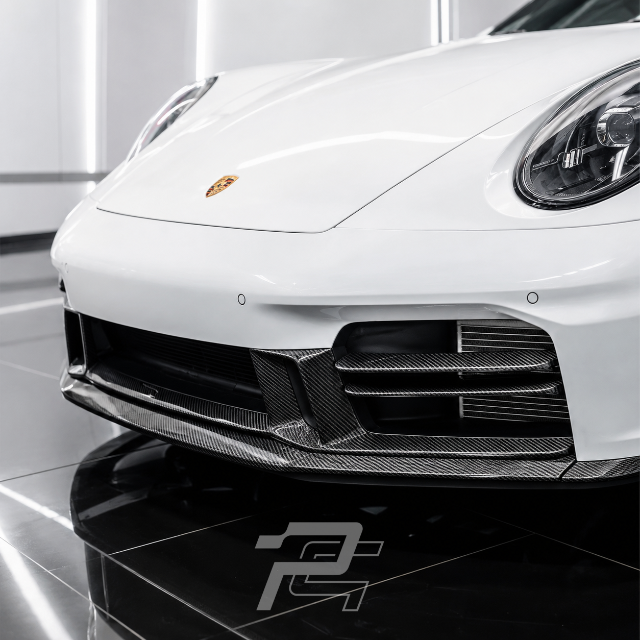 White Porsche car with a carbon fiber front lip spoiler in a showroom setting